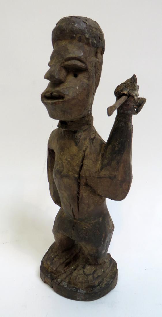 AFRICAN FIGURE WITH SPEAR: African Figure With Spear: A carved figure showing his two front teeth is holding a spear that moves in his hands. There are age cracks through the center and the hand holding the spear is very frag