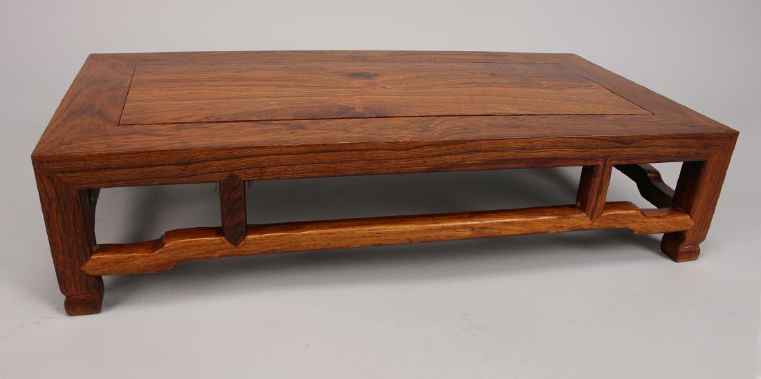 HUANG HUA LI KANG TABLE: Huang Hua Li Kang Table: A Huanghuali kang table that is highly grained with an inset mitered top and open scalloped apron. 23 1/2" X 12" X 5 1/2"