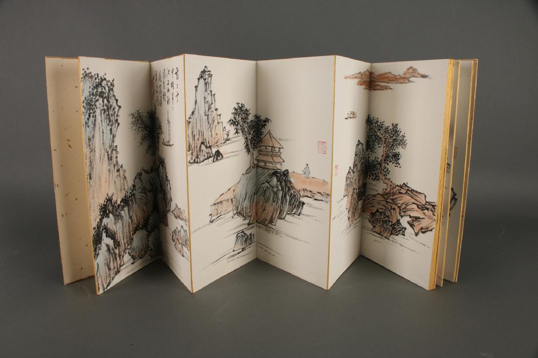 CHINESE PAINTING BOOK OF WATERCOLORS: Chinese Painting Book Of Watercolors: A watercolor album of seascapes with mountains, villages and fishermen in boats along the river. The accordion bound book is in gold brocade. Red artist's seals