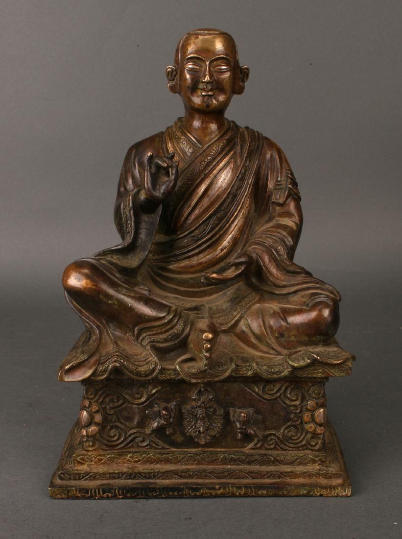 SEATED FIGURE ON A PEDESTAL: Seated Figure On A Pedestal : The figure is seated in the lotus position on a raised plinth. His robes are incised with floral borders. Bottom is incised with a yin yang.