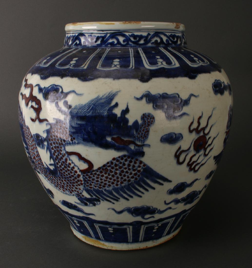 BLACK & WHITE JARDINIERE: Black & White Jardiniere : Two dragons with red scales face each other with a flaming pearl between them on the body of the jardiniere in between a top and bottom borders of lotus petals. The nec