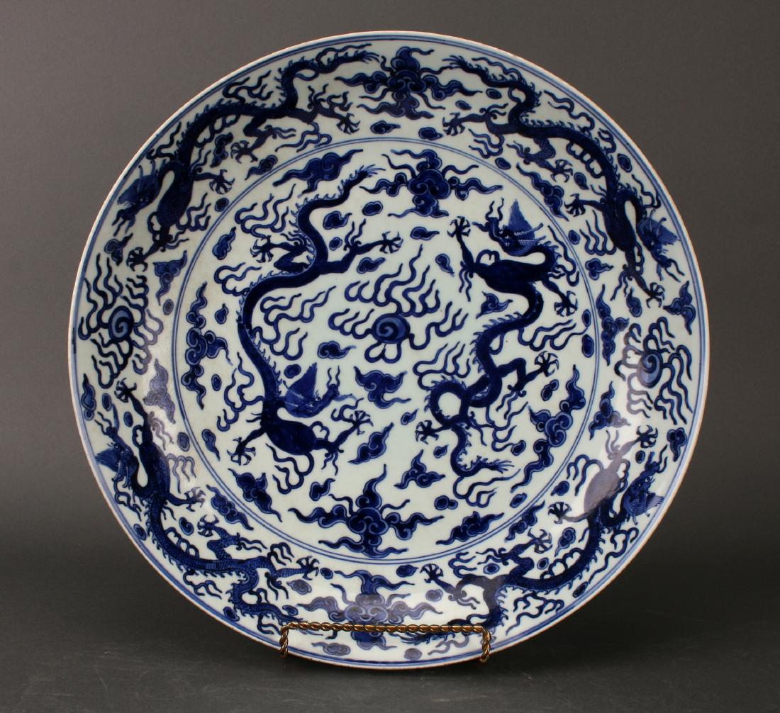 BLUE & WHITE DRAGON CHARGER: Blue & White Dragon Charger: Two dragons face each other and a flaming pearl, surrounded by clouds. A wide outer border is of clouds, dragons, and flaming pearls. The outer rim repeats the same b