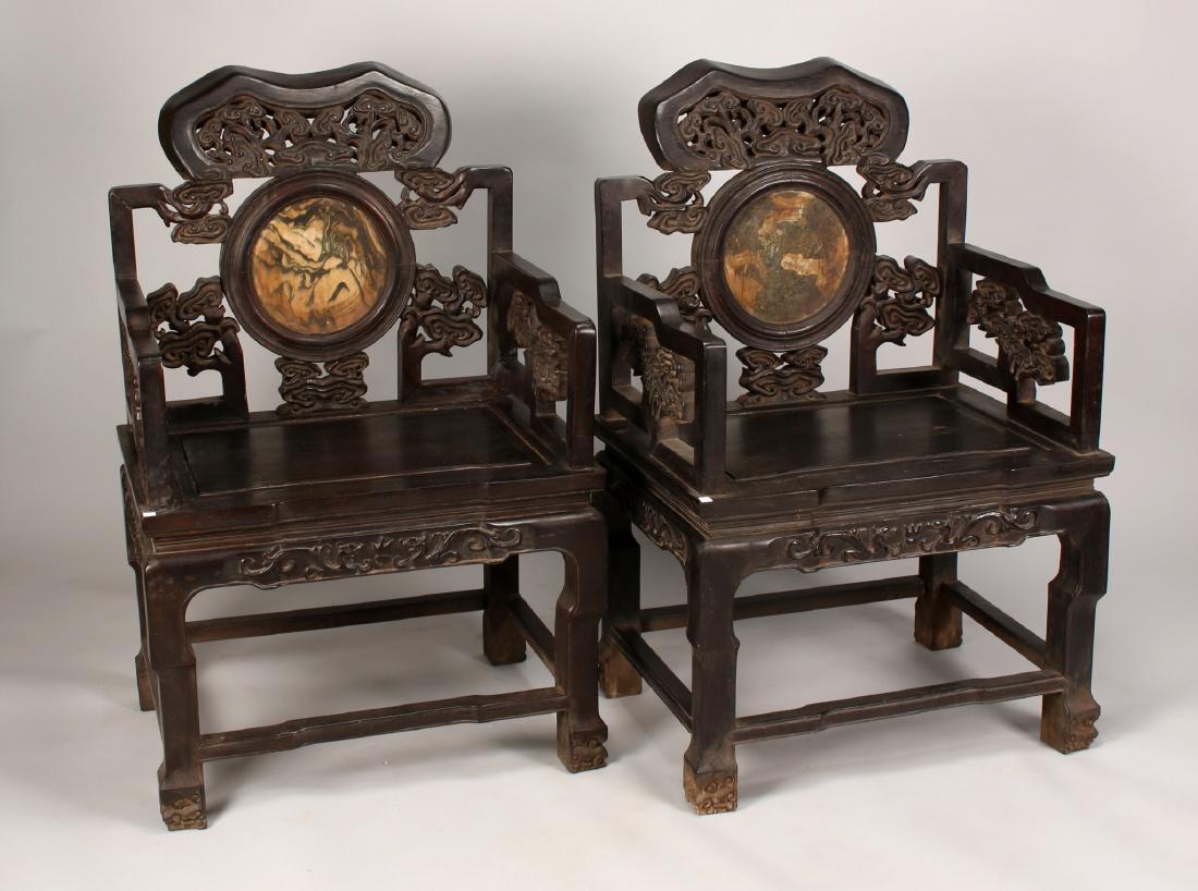 PAIR OF ZITAN CHAIRS WITH STONE INLAY: Pair Of Zitan Chairs With Stone Inlay: Two Zitan armchairs with grained alabaster stone panels. They are elaborately carved with lingzhi mushrooms and dragons on the front aprons.