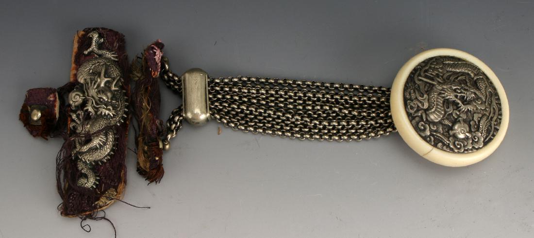 CHINESE SILVER & BONE BRACELET: Chinese Silver & Bone Bracelet: A dragon bracelet, the dragon is embossed and set within a bone button. Ten link chains connect the button to the closure by a silver swivel attachment. The closure