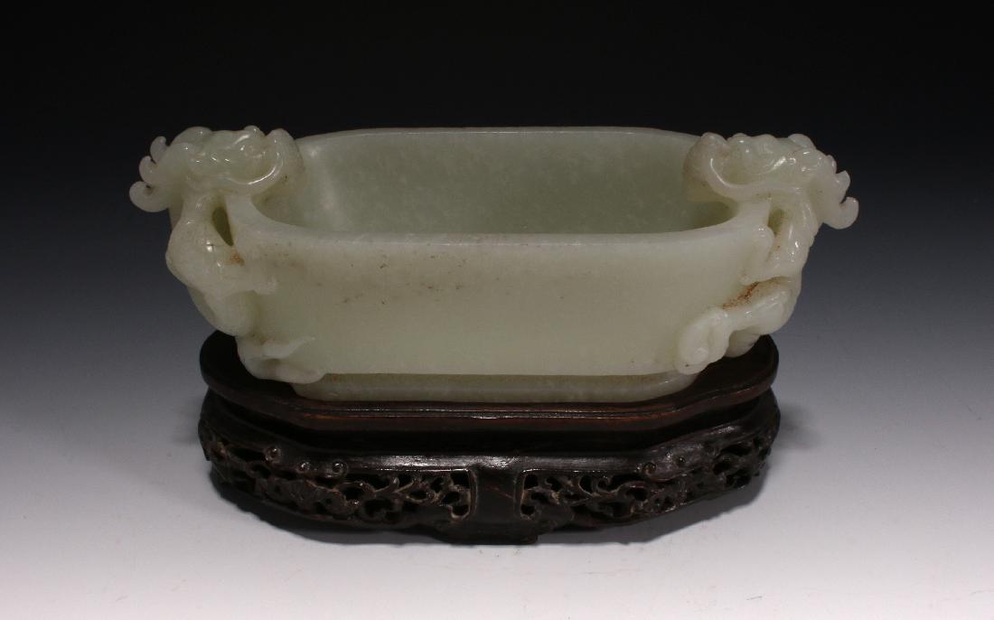 DOUBLE DRAGON WHITE JADE BRUSH WASHER: Double Dragon White Jade Brush Washer: A smooth jade brush washer in pale celadon. The deep oval basin is carved with facing dragons on either end that have incised scales, teeth and curving bodies. T
