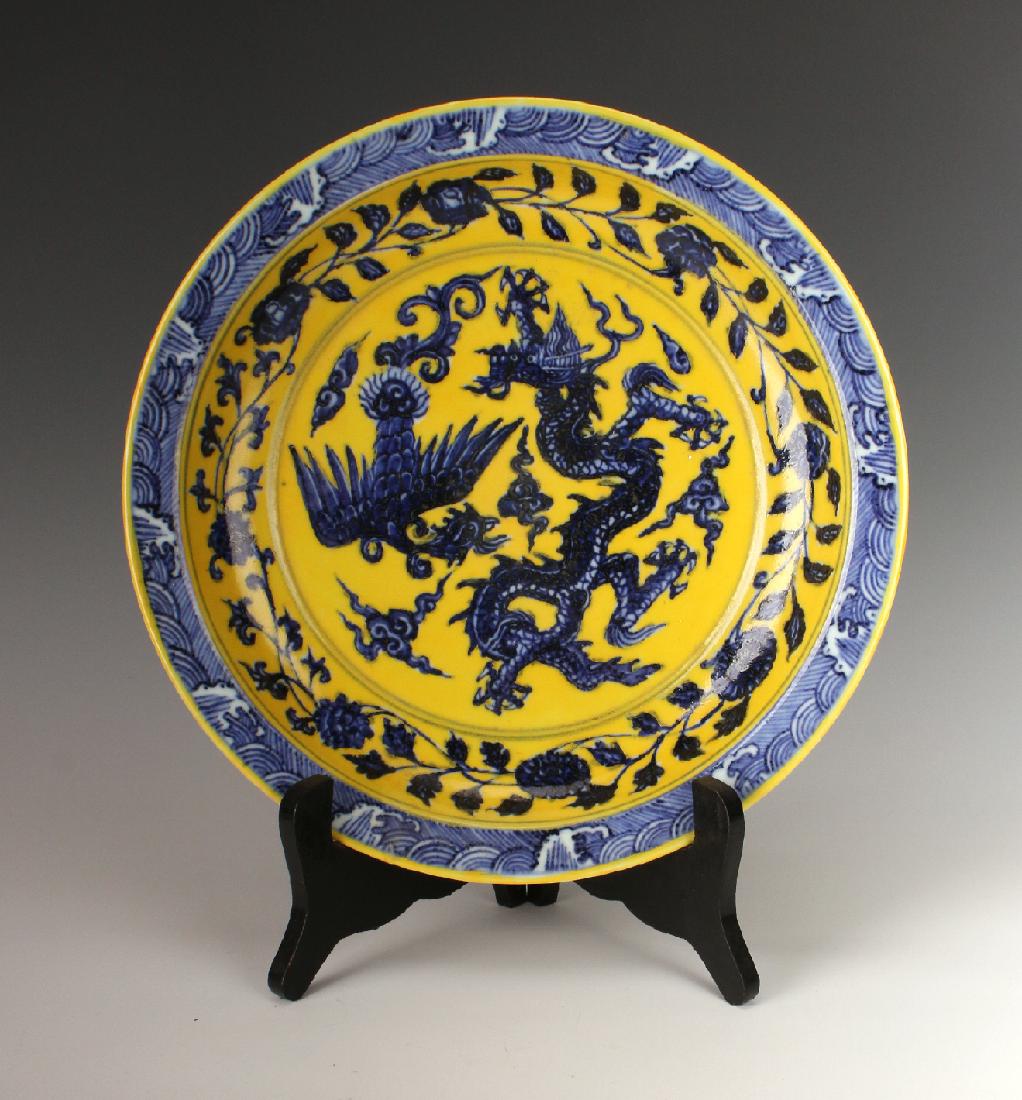 BLUE & YELLOW BOWL WITH DRAGON & PHOENIX: Blue & Yellow Bowl With Dragon & Phoenix: Yellow and cobalt dragon and phoenix in flaming clouds fill the center surrounded by a flower and tendril border within a wave patterned rim. The outs