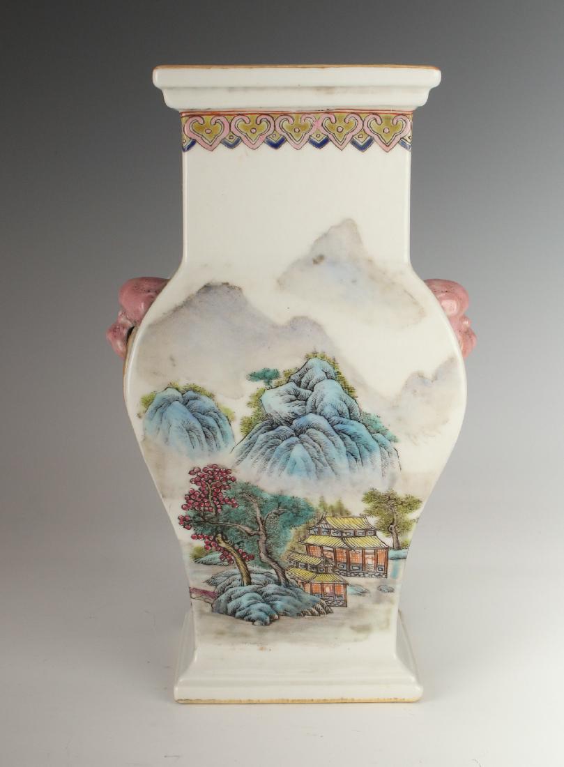 SQUARE PORCELAIN VASE WITH VILLAGE SCENES: Square Porcelain Vase With Village Scenes: A square urn shaped vase with pink dog head handles and attached rings. The body of the vase is decorated in a landscape scene with a village and mountains i