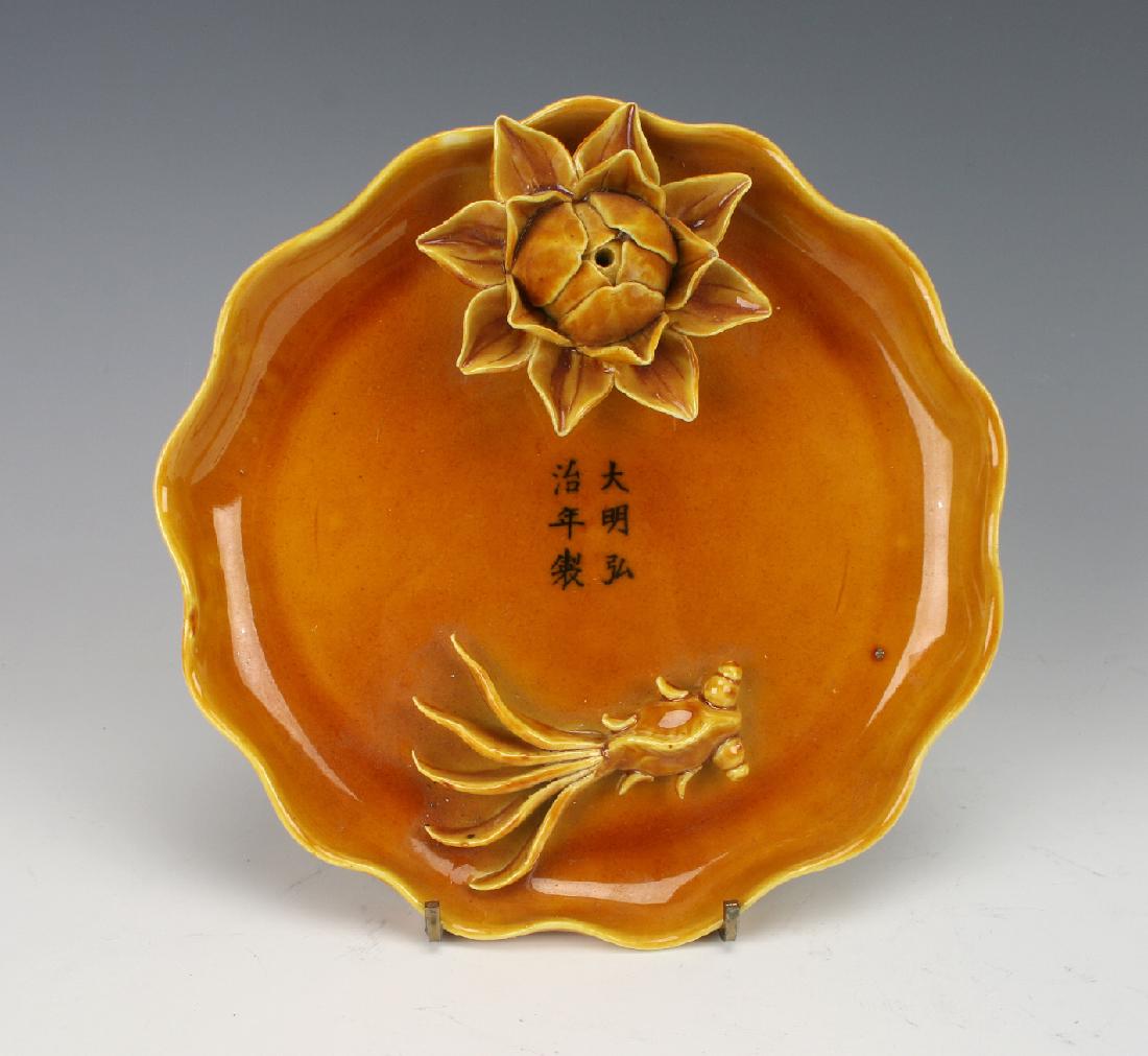 DISH WITH FLOWERS & GOLDFISH: Dish With Flowers & Goldfish: Carved with lotus blossoms and a carp, the lotus has a hole in the center to accommodate a stick of incense. Six character mark in the middle.