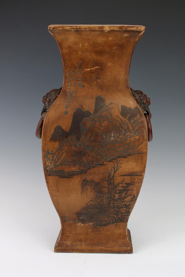 LANDSCAPE VASE: Landscape Vase: A heavy squared vase with lion handles with loose rings on either side of the neck. The landscape scene shows a village on the river with a mountain in the background. Calligraphy and 