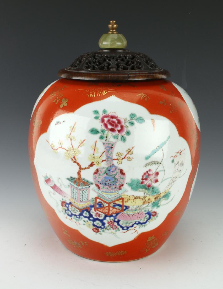 GINGER JAR WITH FLORAL MOTIF: Ginger Jar With Floral Motif: Ginger jar with floral reserves surrounded by an orange background with delicate gold paintings of flowers. The lid is pierced wood with an agate finial.