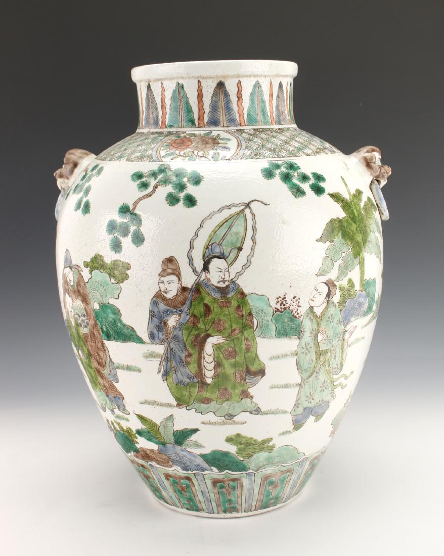 CHINESE FAMILLE VERTE VASE: Chinese Famille Verte Vase: The body is decorated with a garden scene showing people of all ages, one carries a lantern. Others hold offerings to the emperor. Flanked with foo dog handles with attache