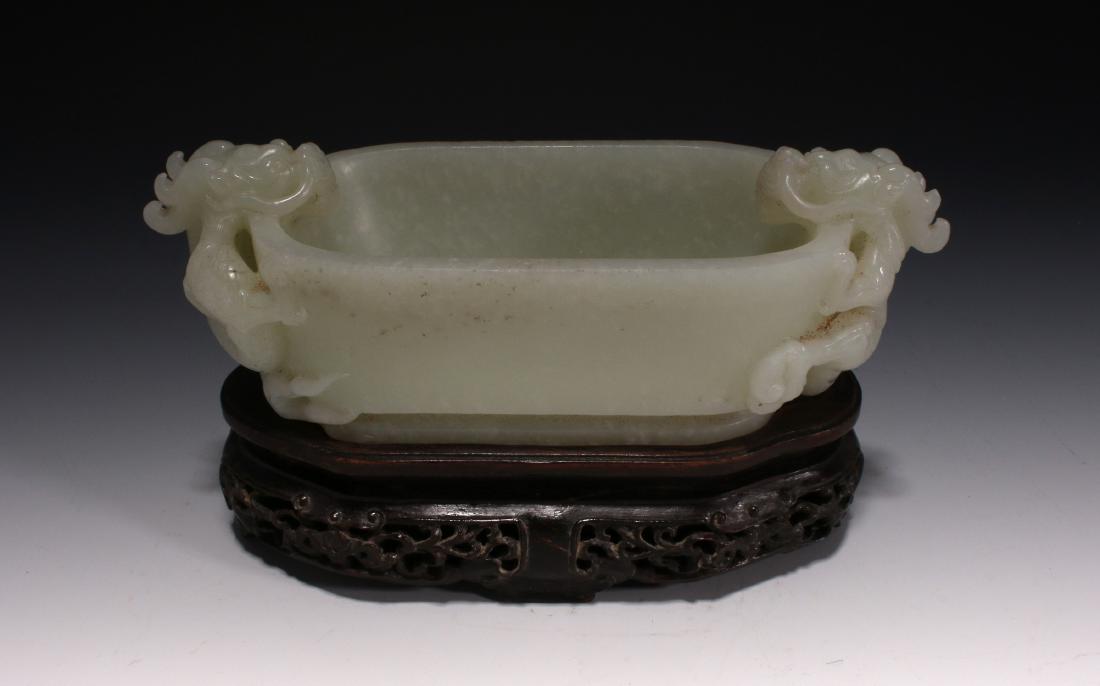 DOUBLE DRAGON WHITE JADE BRUSH WASHER: Double Dragon White Jade Brush Washer: A smooth jade brush washer in pale celadon. The deep oval basin is carved with facing dragons on either end. They have incised scales, teeth and curving bodies. 