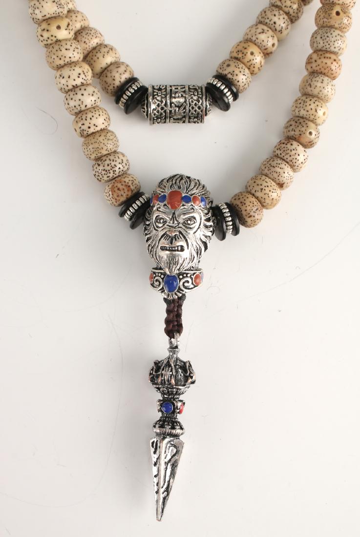 LOTUS BODHI SEED MALA SUN WUKONG BEAD: Lotus Bodhi Seed Mala Sun Wukong Bead: Lotus Bodhi seed mala with silver and enamel. The silver beads have characters on them. The Sun Wukong monkey bead is three dimensional, decorated in colorful bl
