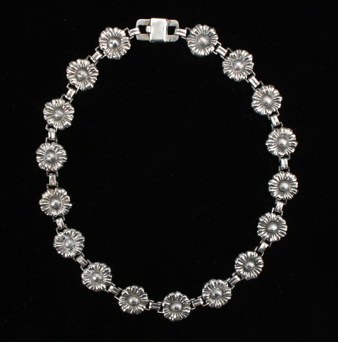 SILVER FLOWER CHOKER: Silver Flower Choker: A delicate repousse flowers are joined by links to form a choker with a tongue clasp form stamped sterling.