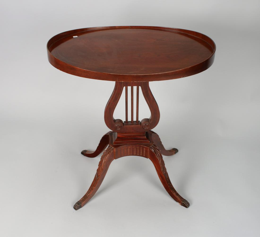 MERSMAN DUNCAN PHYFE LYRE BASE SIDE TABLE: Mersman Duncan Phyfe Lyre Base Side Table: Oval mahogany lyre table with a tray top edge, carved legs, and brass covered feet. Stamped 'Mersman 6651'. 27" X 24" X 18