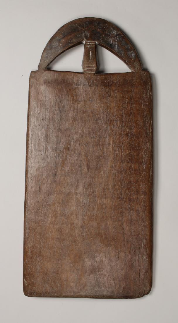 AFRICAN WOODEN BOARD: African Wooden Board: Carved with a moon shaped handle and slightly convex on each side. Incised with lines and a central carved shape with white accents. 20 1/2" X 9 1/2