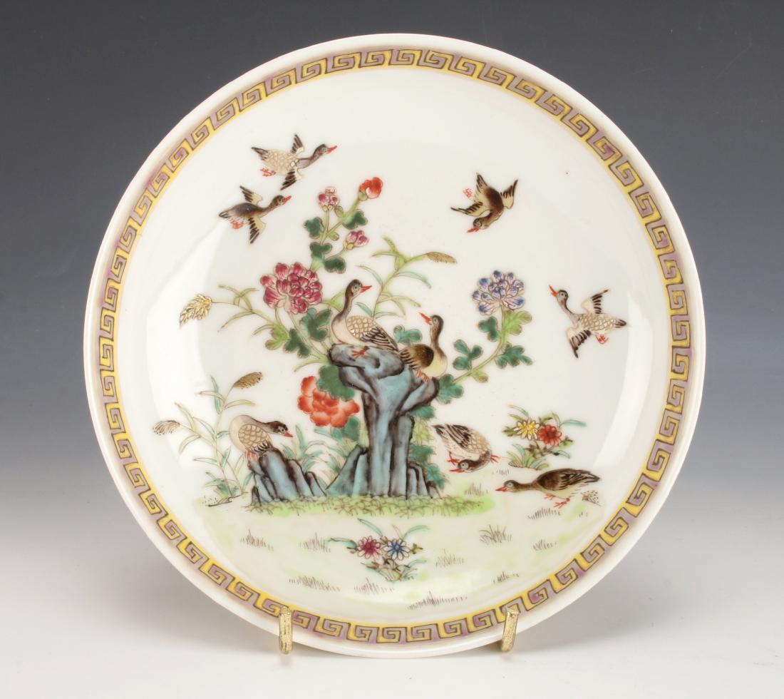 FAMILLE ROSE SHALLOW BOWL WITH DUCKS: FAMILLE ROSE SHALLOW BOWL WITH DUCKS: Ducks crowd the garden scene. They fly above, sit on rocks, and scavenge for food below. There is a yellow and purple meander border. The ducks and flowers are pi