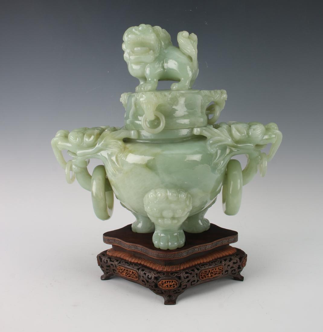LARGE JADE URN WITH WOODEN BASE: LARGE JADE URN WITH WOODEN BASE: Large hardstone lidded censer on a custom wooden base. The lid is topped with a large foo dog finial, with swirling mane and teeth showing. There are three dragon hand