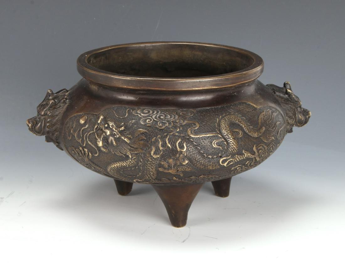 BRONZE DRAGON CENSER: BRONZE DRAGON CENSER: Dragons on either side in a cloud filled sky with two creature handles, on tripod cone shaped feet. Marked on the bottom. 7 1/2" X 3 3/4"