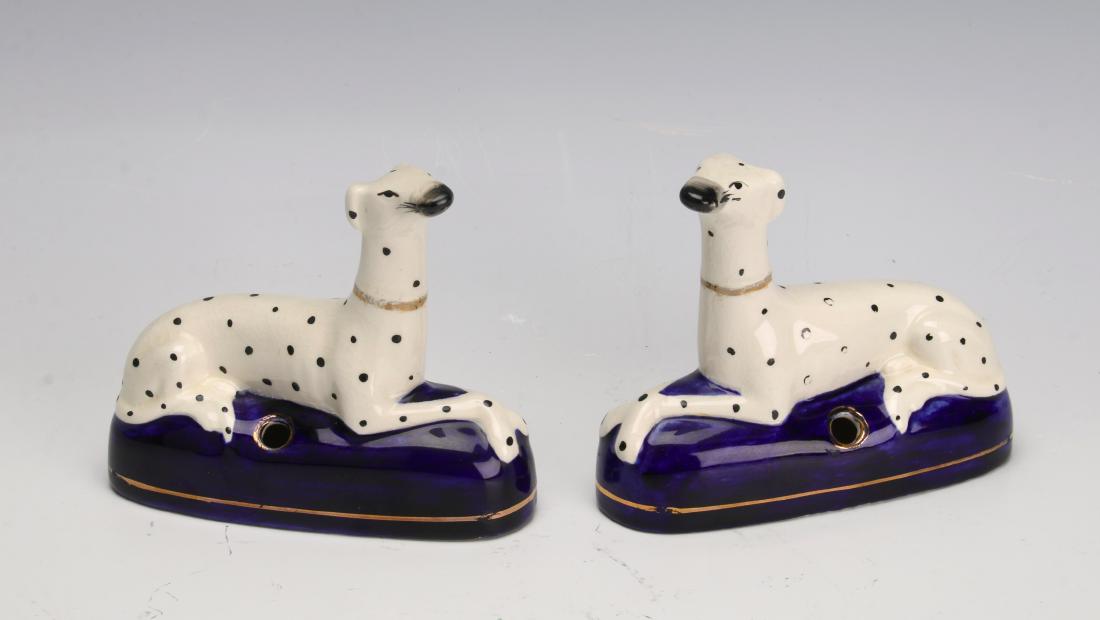 PAIR OF STAFFORDSHIRE DALMATIAN PEN HOLDERS: PAIR OF STAFFORDSHIRE DALMATIAN PEN HOLDERS: Two 1860 - 1880 Staffordshire Dalmatian pen holders in white with black spots and lounging on blue cushions. 5" X 1 1/2&quo