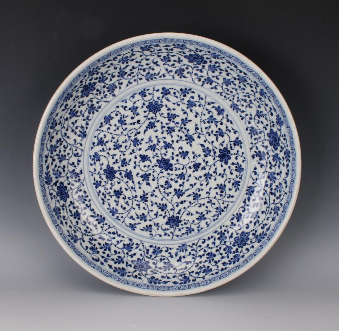 MING DYNASTY BLUE AND WHITE FLORAL CHARGER: MING DYNASTY BLUE AND WHITE FLORAL CHARGER: The center is filled with a flower and tendril pattern surrounded by a flower and tendril border next to a thin circular patterned border. The outer rim rep