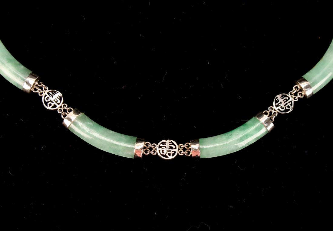 STERLING AND JADE CHOKER: STERLING AND JADE CHOKER: Twelve curving links of polished jade attached with sterling end caps and round pierced characters. Designed to drape elegantly around the neck. With tongue clasps and figure