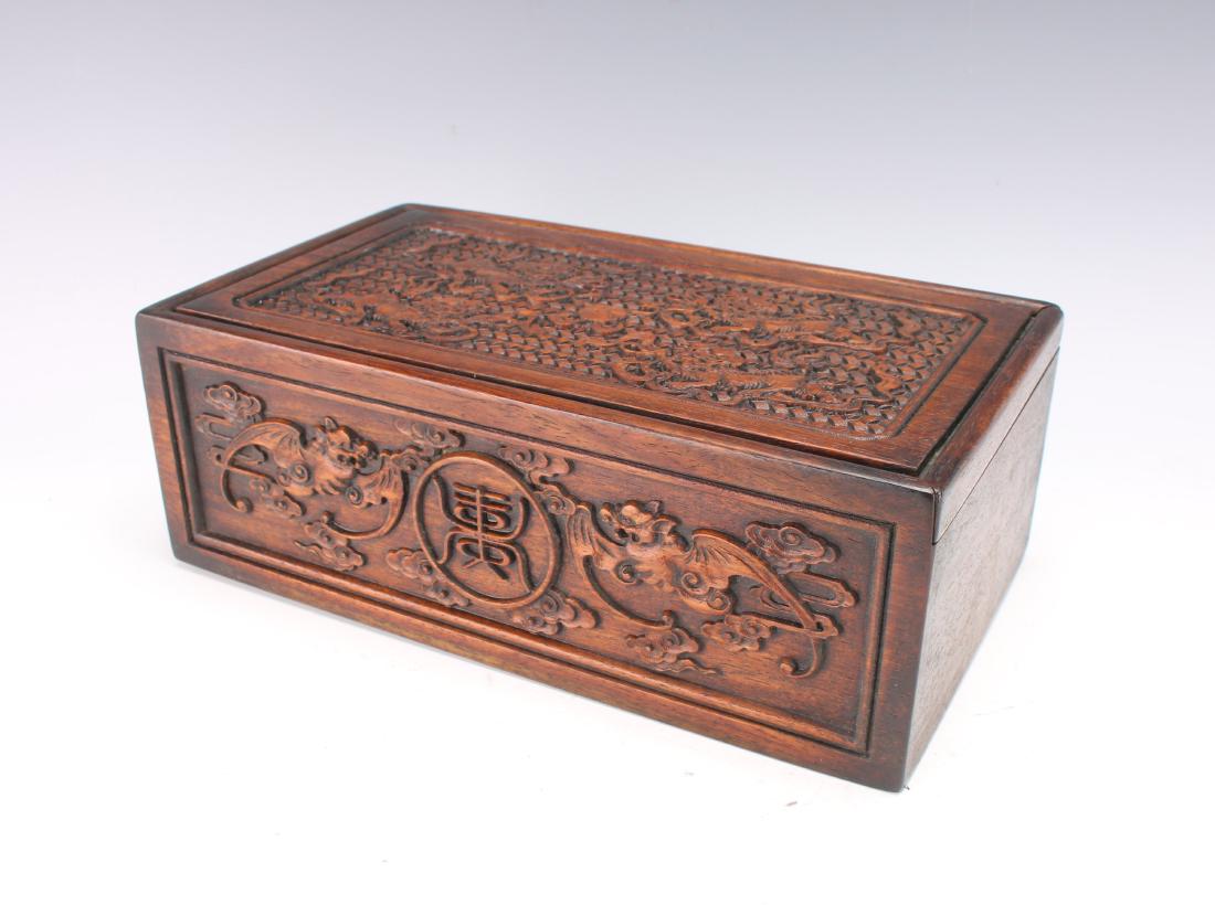 DETAILED CARVED WOODEN BOX WITH FOO DOGS: DETAILED CARVED WOODEN BOX WITH FOO DOGS: The box is carved on all sides. Four foo dogs surround a ball on a background that is carved to look woven on the lid. The lid slides open to reveal the stora