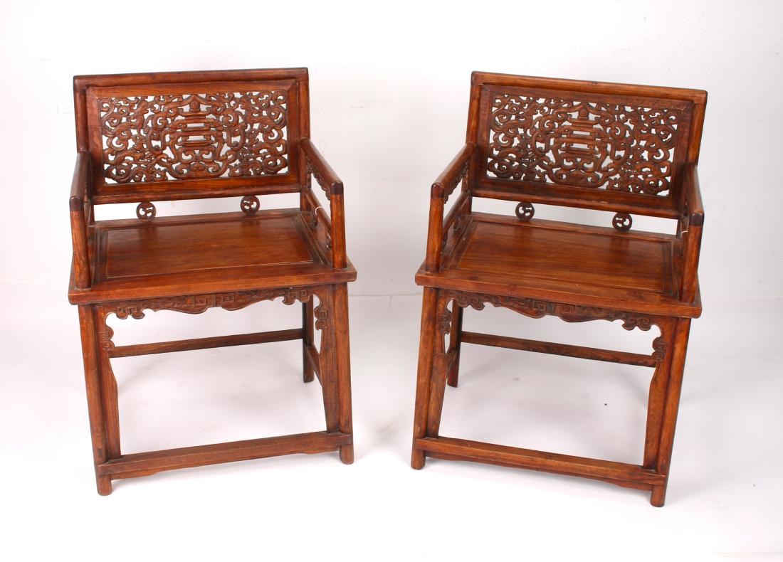 PAIR OF HUANGHUALI ROSE CHAIRS: PAIR OF HUANGHUALI ROSE CHAIRS: Pierced and carved rose chairs. The backs are pierced and carved with a central pagoda design surrounded by dragons. Circular dragon medallions connect the chair back a