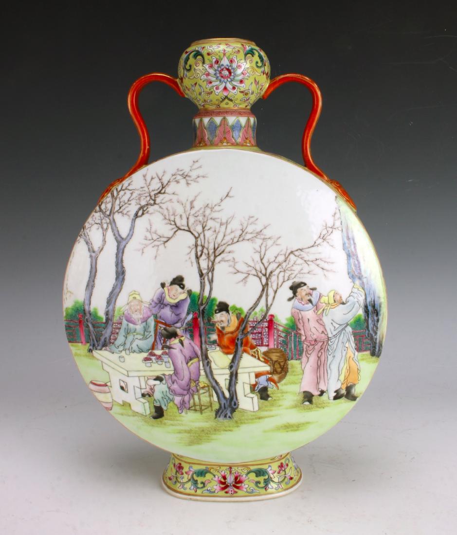 FAMILLE JUANE MOON FLASK: FAMILLE JUANE MOON FLASK: Moon flask with a garlic head top. Orange curved handles with applied patterns of gold connect the top to the base. One side of the body is decorated with scholars seated aro
