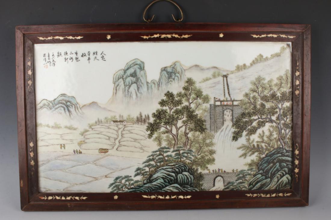 PORCELAIN LANDSCAPE PANEL: PORCELAIN LANDSCAPE PANEL: A village and dam scene with mountains in the distance. People are touring a village aqueduct by bus. They can be seen near the bus, on a bridge, and atop the dam. Calligrap