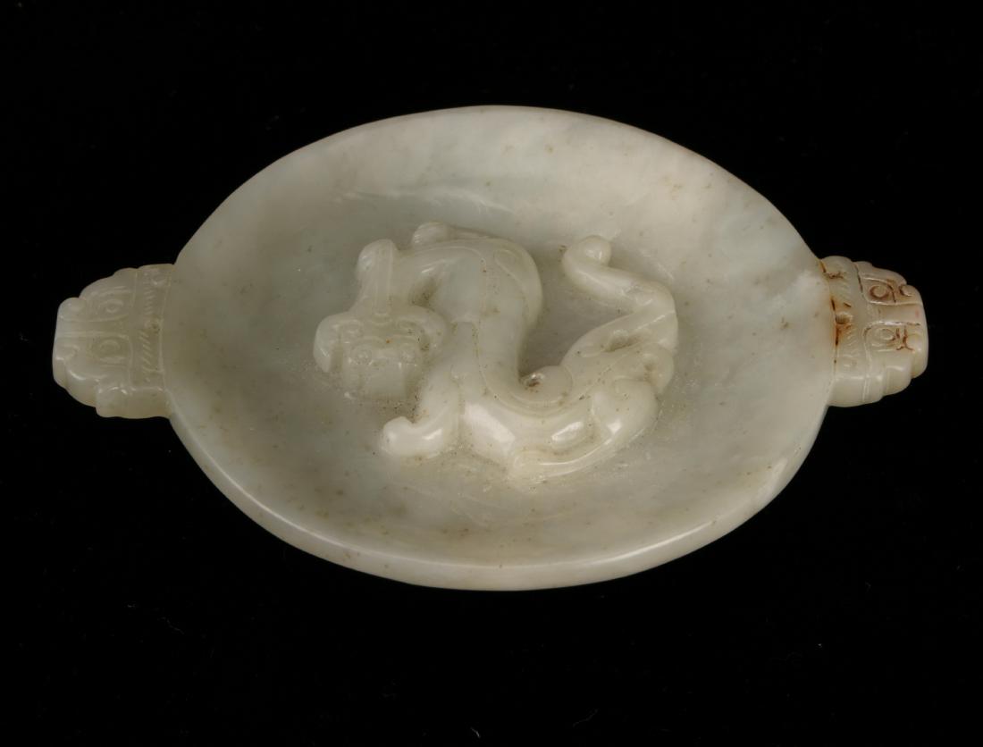 JADE DRAGON CENSER: JADE DRAGON CENSER : Small jade center with a dragon carved in the center. Either side has archaic dragon head handles. 3 3/4" X 2 3/4" $200 - $400