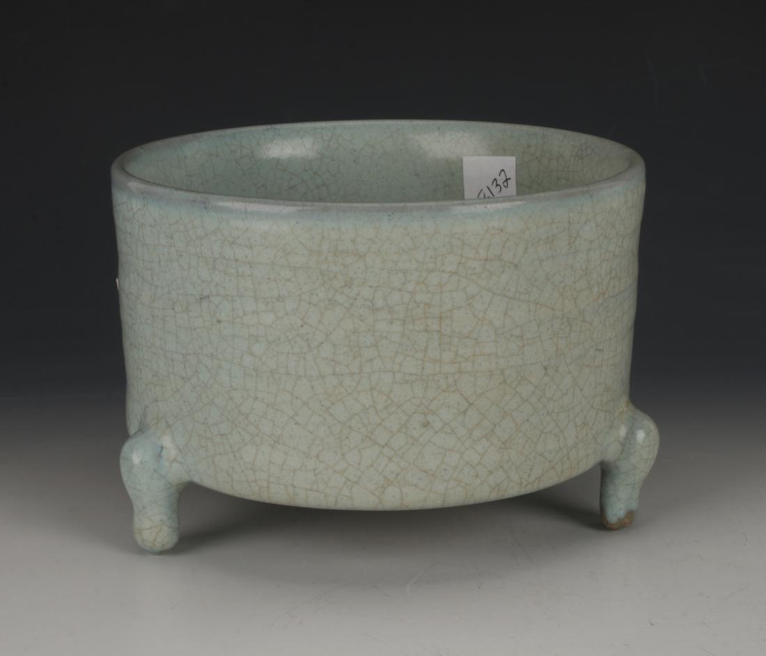 CELADON CRACKLE TRIPOD CENSER: CELADON CRACKLE TRIPOD CENSER: Circular with straight sides and claw tripod feet. The celadon glaze has an over all craquelure finish. The bottom has incised characters in gold and accented in red.