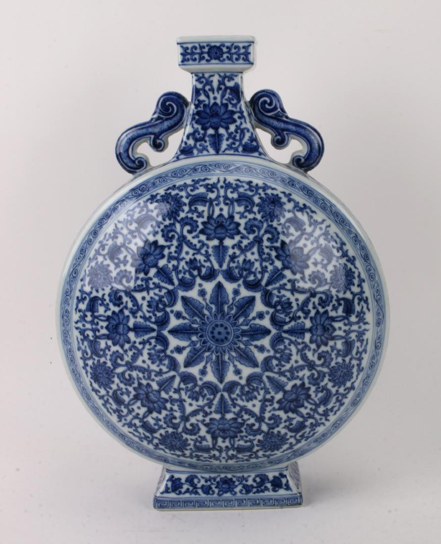 BLUE AND WHITE QIANLONG MOON FLASK: BLUE AND WHITE QIANLONG MOON FLASK: Pierced swirl handles on both sides. The neck has lotus and tendril patterns, as do the sides. The front and back are lotus and tendril patterns that form a circle 