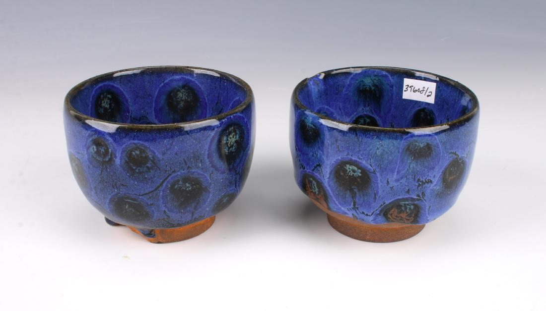 PAIR ANTIQUE PEACOCK GLAZED CUPS: PAIR ANTIQUE PEACOCK GLAZED CUPS: Two cups in a peacock glaze. Has a thick drip glaze that stops above the unglazed bottom and foot. 3 1/2" X 2 1/2" $300