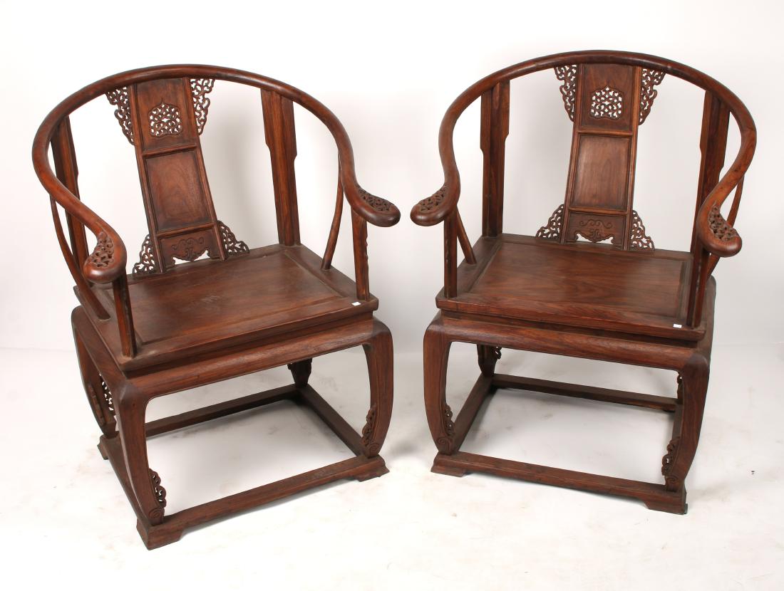 PAIR QING HUANGHUALI HORSESHOE CHAIRS: PAIR QING HUANGHUALI HORSESHOE CHAIRS: Fine pierced horseshoe chairs with finely carved tendril patterns on arm rest and back splats. The back splats have carved central medallions and pierced flanges