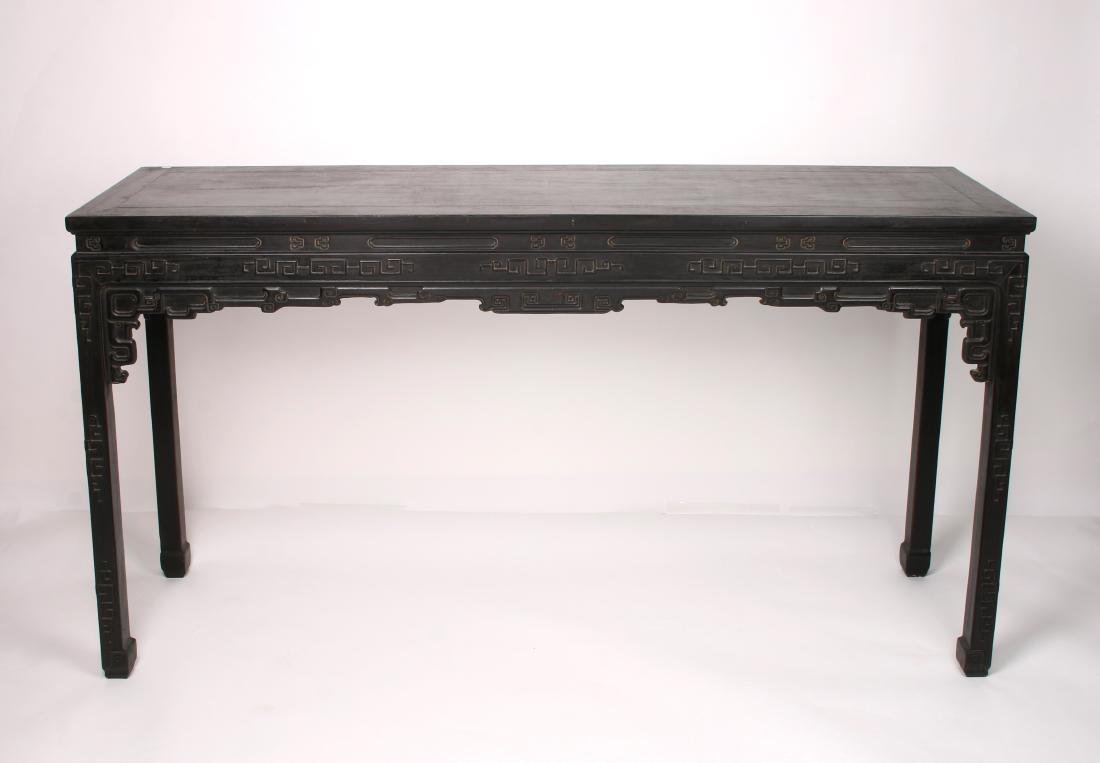 ZITAN PAINTING TABLE: ZITAN PAINTING TABLE: Zitan painting table with a floating panel top, apron carved and incised in archaic patterns, the legs continue the geometric patterns and end in hoof feet.