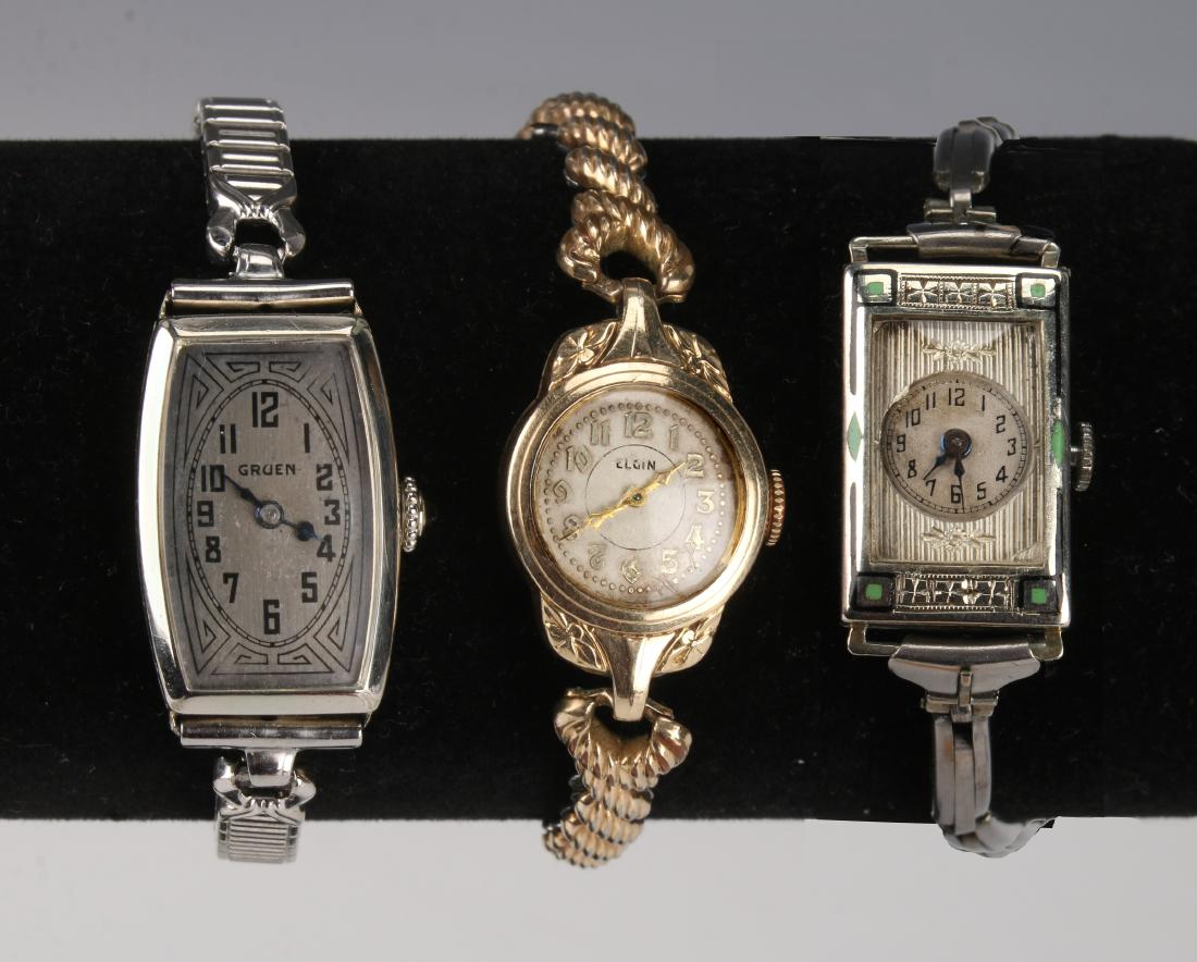 THREE LADIES WATCHES, 18K LECOULTRE 14K GRUEN: THREE LADIES WATCHES, 18K LECOUTRE 14K GRUEN: Three vintage ladies wrist watches by LeCoultre, Elgin, and Gruen. Art Deco watch is LeCoultre 18K white gold and enamel. The Elgin watch has a speidel ba