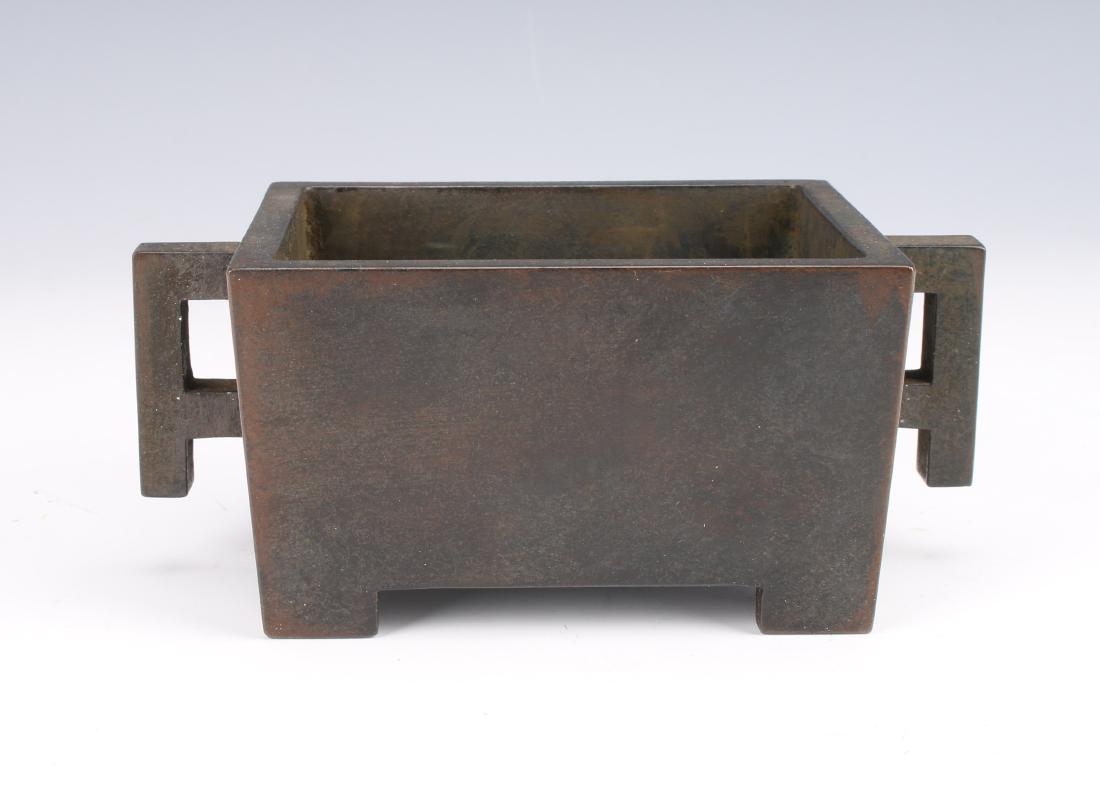 ANTIQUE CHINESE RECTANGULAR BRONZE CENSER: ANTIQUE CHINESE RECTANGULAR BRONZE CENSER: Rectangular bronze censer with geometric pierced handles. Has a dark mottled patina. Marked on the bottom. 5 1/2" X 3" X