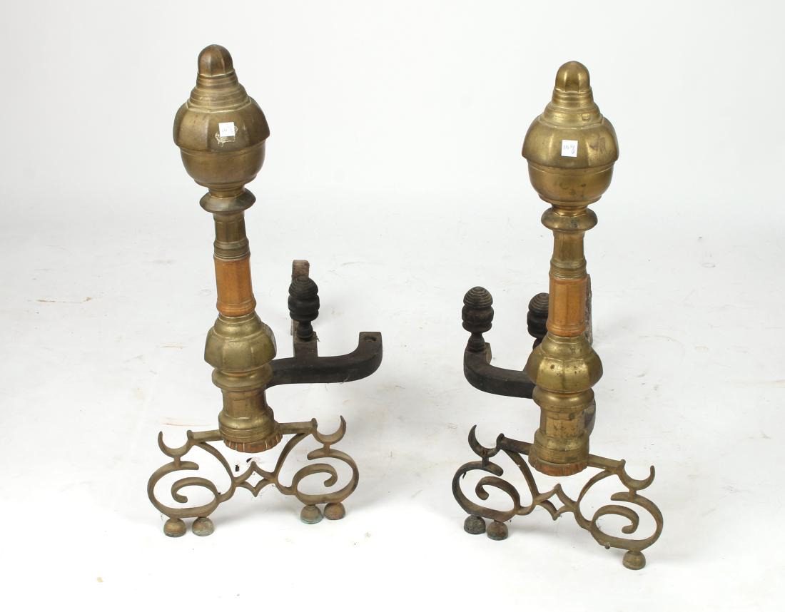 LARGE UNUSUAL BRASS ANDIRONS: LARGE UNUSUAL BRASS ANDIRONS: With faceted finials over large column that sits on a scroll work base and semicircular feet. 15" X 25" X 26" $500 - $8