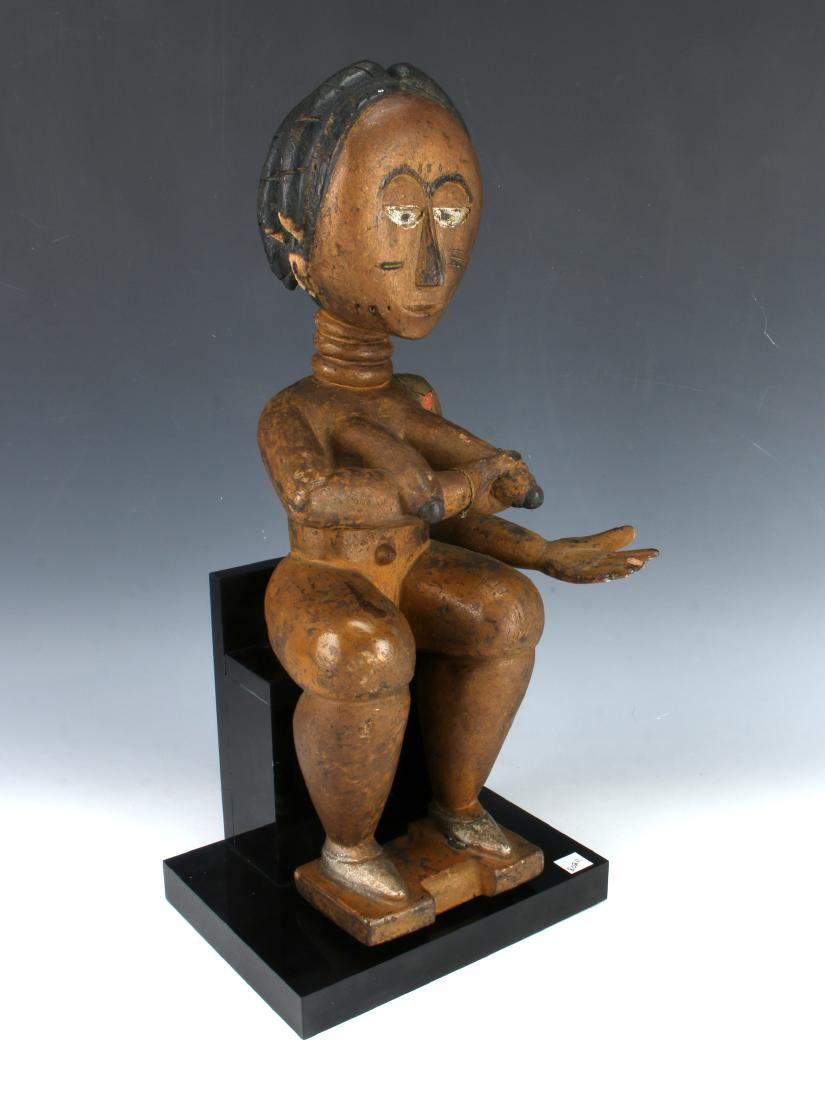 WOODEN CARVING OF NURSING MOTHER: WOODEN CARVING OF NURSING MOTHER: A woman sits with arm out (possibly to cradle the head of a baby) ready to nurse. On custom lucite stand. 8" X 7" X 18"