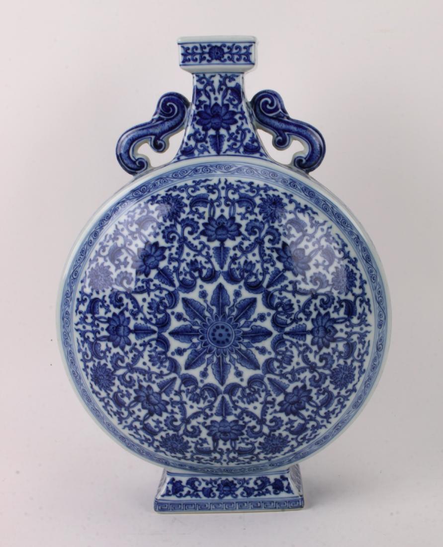 BLUE AND WHITE QIANLONG MOON FLASK: BLUE AND WHITE QIANLONG MOON FLASK: Pierced swirl handles on both sides. The neck has lotus and tendril patterns, as do the sides. The front and back are lotus and tendril patterns that form a circle 