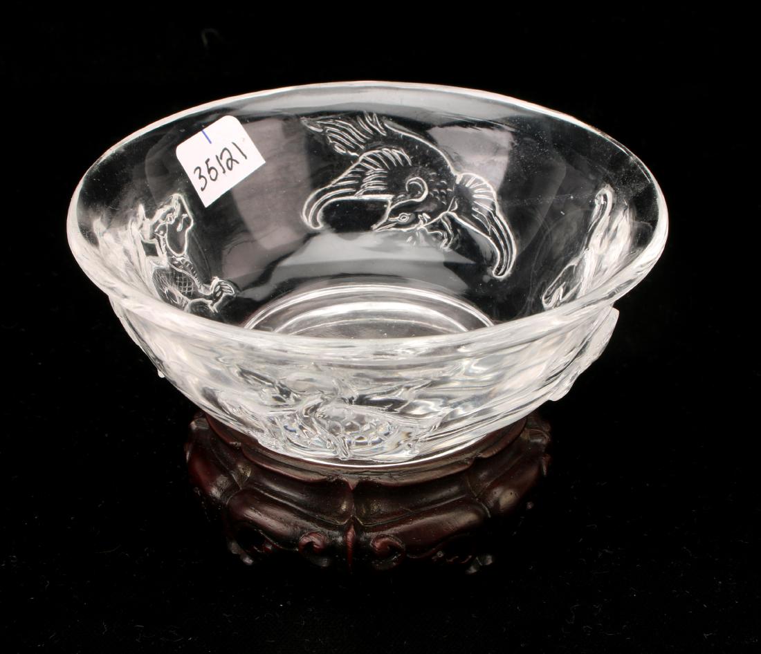 CLEAR PEKING GLASS BOWL WITH WOODEN STAND: CLEAR PEKING GLASS BOWL WITH WOODEN STAND: There is a tiger, turtle, bird, and dragon around the body of the bowl. On a custom wooden stand. 4" X 2 3/4" $