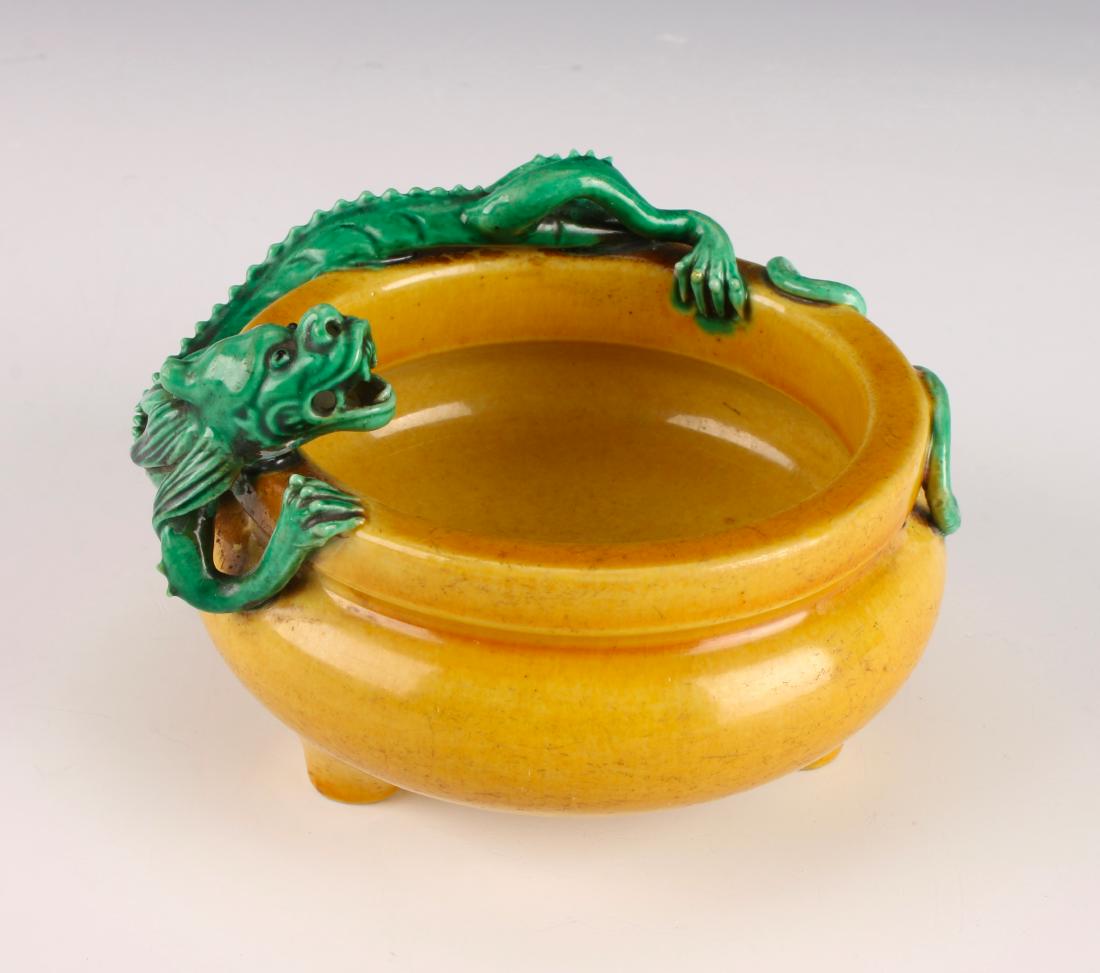 YELLOW CENSER WITH GREEN DRAGON: YELLOW CENSER WITH GREEN DRAGON: Yellow glazed censer on tripod feet. A green applied dragon encircles the outer rim with detailed claws, spine, mane, and facial features. Marked on the bottom.