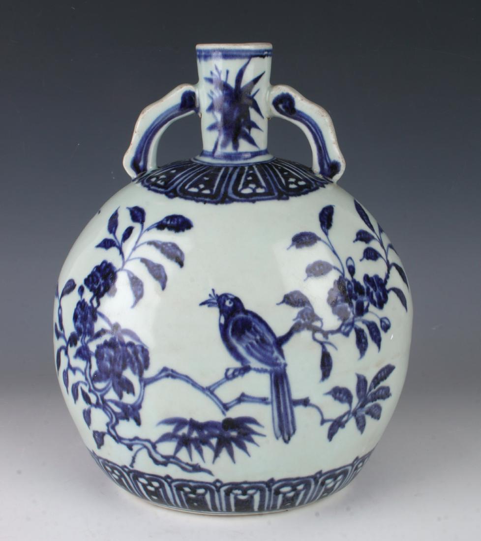 BLUE AND WHITE MOON FLASK: BLUE AND WHITE MOON FLASK : Blue and white moon flask decorated with a bird perched on a branch on both sides. The shoulder and bottom have a stylized lotus petal border. The neck is painted with bamb
