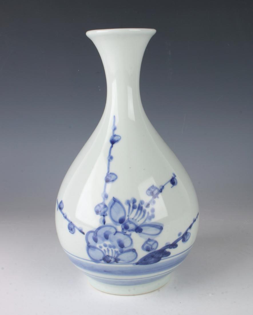 BLUE AND WHITE VASE: BLUE AND WHITE VASE : A graceful shape painted with flowers and branches above two lined borders. Marked on the bottom. 5 1/2" X 9" $100 - $200