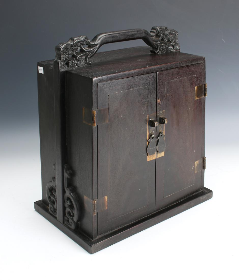 TWO DOOR ZITAN JEWELRY CHEST: TWO DOOR ZITAN JEWELRY CHEST: The sides and handle are carved to mimic the sides of a tiered lunch box. Has two shelves and two inner doors. The sides of the handle end in ruyi form trees. <