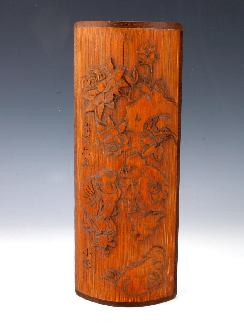 CARVED BAMBOO WRIST REST: CARVED BAMBOO WRIST REST : Carved with two men whispering in a garden among blooming flowers. Incised characters on the left. 3 3/4" X 10" $100 - $200
