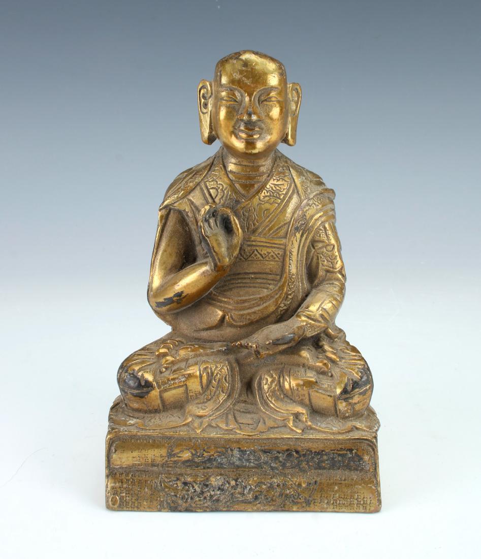 SMALL GILT BRONZE BUDDHA: SMALL GILT BRONZE BUDDHA: Seated on a pedestal of books. Marked on the back. 3 1/2" X 5 1/2" $100 - $200 Shipping: We are
