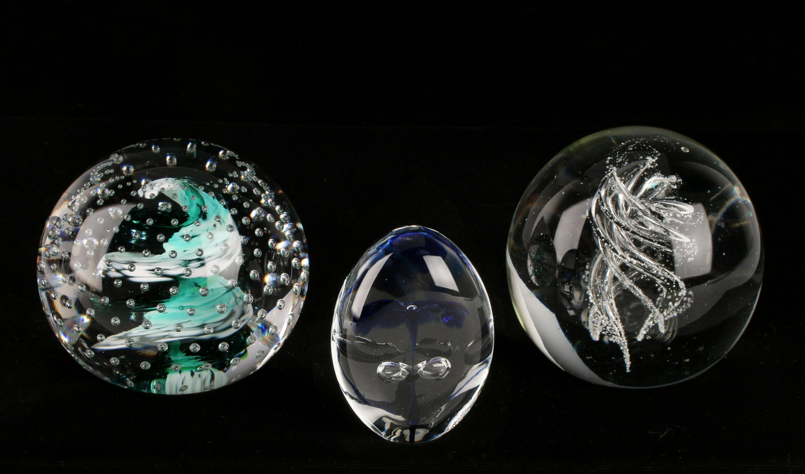3 BLOWN ART GLASS CONTROLLED BUBBLE PAPERWEIGHTS: 3 BLOWN ART GLASS CONTROLLED BUBBLE PAPERWEIGHTS: Phthalo green Wheaton Village paperweight is stamped JM & WV. Has green and white swirling center with controlled bubbles. Clear paperweight with 