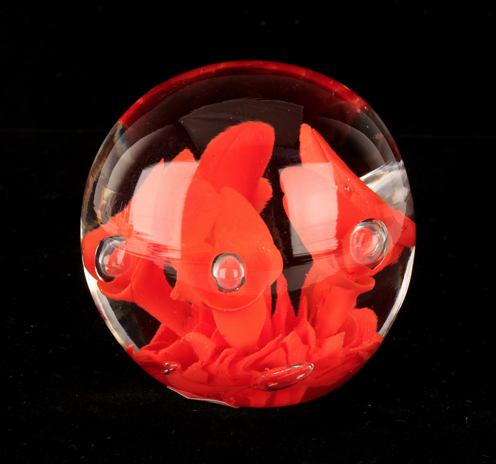 JOE ST. CLAIR CONTROLLED BUBBLE PAPERWEIGHT: JOE ST. CLAIR CONTROLLED BUBBLE PAPERWEIGHT: Red cased flower in blown art glass paperweight with controlled bubbles. Signed Joe St. Clair. 3" $100 - $200 <